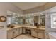 Bright bathroom featuring a soaking tub, glass shower, and vanity with unique vessel sink and natural stone tile at 1290 Clays Trl, Oldsmar, FL 34677