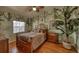 Unique bedroom featuring lush jungle themed wallpaper, hardwood floors, and ceiling fan at 1290 Clays Trl, Oldsmar, FL 34677