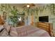 Unique bedroom featuring lush jungle themed wallpaper, hardwood floors, and ceiling fan at 1290 Clays Trl, Oldsmar, FL 34677
