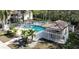 Aerial view of the community pool area with white fencing and tropical landscaping at 1290 Clays Trl, Oldsmar, FL 34677