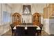 Elegant dining room features a modern chandelier, hardwood floors, and custom wood cabinets at 1290 Clays Trl, Oldsmar, FL 34677