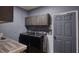 Well-equipped laundry room featuring modern washer, dryer, and stylish overhead cabinets at 1290 Clays Trl, Oldsmar, FL 34677