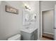 Bathroom vanity with a grey cabinet, mirror, and access to another room at 1405 Kensington Woods Dr, Lutz, FL 33549