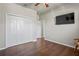 Bedroom with modern hardwood floors, closet, and a television mounted to the wall at 1405 Kensington Woods Dr, Lutz, FL 33549