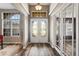Welcoming foyer with elegant double doors, hardwood flooring, and decorative lighting at 1405 Kensington Woods Dr, Lutz, FL 33549
