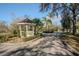 Charming white gazebo at the entrance of Kensington Estates surrounded by lush green landscaping and a gated entrance at 1405 Kensington Woods Dr, Lutz, FL 33549