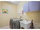 Practical laundry room with a utility sink, cabinets, and a washer and dryer at 1405 Kensington Woods Dr, Lutz, FL 33549