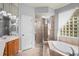 Well-appointed main bathroom with a stand up shower, glass block window, and a soaking tub at 1405 Kensington Woods Dr, Lutz, FL 33549