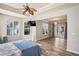 Large main bedroom with a ceiling fan, wood flooring, and access to a private outdoor living space at 1405 Kensington Woods Dr, Lutz, FL 33549