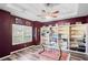 Well-lit home office with a large window, built-in shelving, and a stylish ceiling fan at 1405 Kensington Woods Dr, Lutz, FL 33549