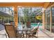 Outdoor dining area with a view of the pool and lush backyard, perfect for entertaining at 1405 Kensington Woods Dr, Lutz, FL 33549