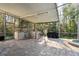 Well-equipped outdoor kitchen with built-in grill and beverage cooler in screened-in patio at 1405 Kensington Woods Dr, Lutz, FL 33549