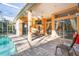 Covered patio with a view of the sparkling pool, perfect for outdoor dining and relaxation at 1405 Kensington Woods Dr, Lutz, FL 33549
