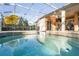 Relaxing screened-in spa with clear water and outdoor seating and dining area at 1405 Kensington Woods Dr, Lutz, FL 33549