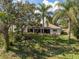 Expansive backyard featuring a covered lanai and lush landscaping provides a tranquil outdoor retreat at 1472 Ivydale Rd, Spring Hill, FL 34606
