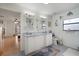Bright bathroom with double sinks, decorative mirrors, and white cabinets at 1472 Ivydale Rd, Spring Hill, FL 34606