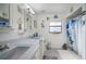 Well-lit bathroom with a double vanity and a shower-tub combination featuring decorative accents at 1472 Ivydale Rd, Spring Hill, FL 34606