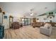 Spacious living room featuring hardwood floors, a ceiling fan, and sliding glass doors to the backyard at 1472 Ivydale Rd, Spring Hill, FL 34606