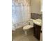Cozy bathroom featuring a floral shower curtain, tiled accent wall, modern toilet and an ornate vanity at 1811 Ridge S Rd, Largo, FL 33778