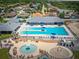Aerial view of the community pool featuring a splash pad, lounge chairs, and umbrellas at 2111 Roanoke Springs Dr, Ruskin, FL 33570