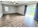 Spacious living room featuring wood floors, fan, and sliding glass doors to the outside at 2111 Roanoke Springs Dr, Ruskin, FL 33570