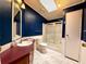 Bathroom featuring dark blue walls, a skylight, and a shower-tub combo with sliding glass doors at 222 N Saint George Cir, Apollo Beach, FL 33572