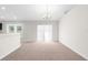 Bright living room with neutral carpet, a modern chandelier, and sliding door access at 2494 Caretta Ave, Spring Hill, FL 34609