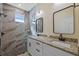 Modern bathroom featuring a double vanity, granite counters, and a walk-in shower with marble-style tile at 4006 N 27Th St, Tampa, FL 33610