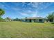 Spacious backyard featuring a well-maintained lawn, mature trees, and a view of the neighborhood at 5043 Escalante Dr, North Port, FL 34287