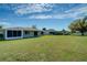 Large backyard with mature trees and view of the rear of the house at 5043 Escalante Dr, North Port, FL 34287