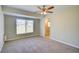 Neutral bedroom with a window and a view, featuring a ceiling fan and light-colored carpet at 5043 Escalante Dr, North Port, FL 34287