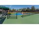 The community's pickleball court with colorful surfaces, shaded area, and black chain link fence at 5062 Stone Harbor Cir, Wimauma, FL 33598