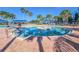 Circular community pool surrounded by palm trees and lounge seating with easy access steps at 5062 Stone Harbor Cir, Wimauma, FL 33598