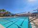 Bright and clear community swimming pool with lane markers, lounge seating and sunshades on a sunny day at 5062 Stone Harbor Cir, Wimauma, FL 33598