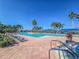 Large community pool with sunbathers lounging and swimmers enjoying the water on a sunny day at 5062 Stone Harbor Cir, Wimauma, FL 33598