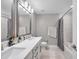 Modern bathroom featuring double sinks, white cabinets, a shower, and a toilet at 5351 Bridge St # 81, Tampa, FL 33611