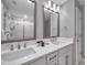 Bathroom with double vanity, undermount sinks, chrome fixtures, framed mirrors and large walk-in shower at 5351 Bridge St # 81, Tampa, FL 33611