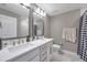 Modern bathroom featuring double sinks, white cabinets, shower, and a toilet at 5351 Bridge St # 81, Tampa, FL 33611