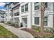 Attractive townhouse exterior showcasing a sidewalk and well-maintained bushes, and a palm tree at 5351 Bridge St # 81, Tampa, FL 33611