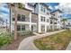 Charming townhome exterior featuring balconies, lush landscaping, and a welcoming walkway to the entrance at 5351 Bridge St # 81, Tampa, FL 33611