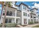 Beautiful three-story townhome featuring a welcoming front porch, balcony and manicured landscaping at 5351 Bridge St # 81, Tampa, FL 33611