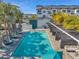 Community pool with lounge areas and palm trees creating a relaxing outdoor retreat at 5351 Bridge St # 81, Tampa, FL 33611