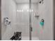 Walk-in shower featuring white tiled walls with dark grout and frameless glass door and chrome fixtures at 5351 Bridge St # 81, Tampa, FL 33611