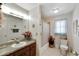 Well-lit bathroom featuring a vanity, tiled shower with sliding door, and standard toilet at 612 Allegheny Dr, Sun City Center, FL 33573