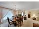 Formal dining room with chandelier, large window with drapes, and access to living area at 612 Allegheny Dr, Sun City Center, FL 33573