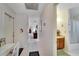 Hallway with tile flooring and white walls with access to bathroom and desk at 612 Allegheny Dr, Sun City Center, FL 33573