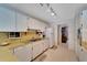 Well-lit kitchen with white appliances, plenty of counter space, and patterned wallpaper at 612 Allegheny Dr, Sun City Center, FL 33573