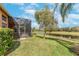 Relaxing view of a screened lanai and water from the luscious backyard at 5062 Stone Harbor Cir, Wimauma, FL 33598