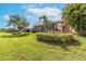 Lush backyard with mature palms, enclosed lanai, and lake view at 5062 Stone Harbor Cir, Wimauma, FL 33598