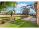 View of the screen enclosed lanai, pond, and trees, showing the depth of the backyard at 5062 Stone Harbor Cir, Wimauma, FL 33598